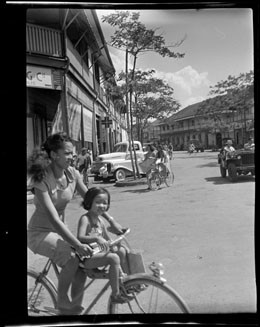 Scène de rue à Papeete, femme et enfant à vélo (1952)