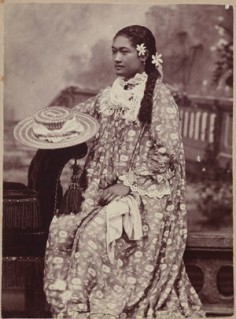 Portrait studio d’une jeune femme en robe à fleurs (1885)
